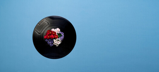 top view of a vinyl disc record with flowers around