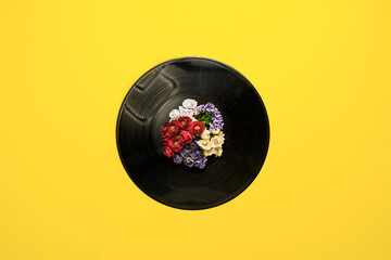 top view of a vinyl disc record with flowers around