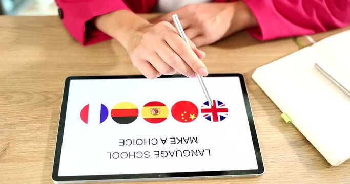 Woman hand uses tablet with her fingers and an app is popular free platform for learning languages