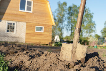 a shovel stuck in the ground at the dacha