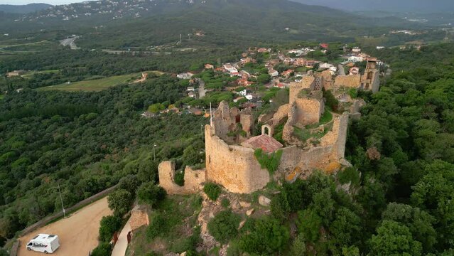 Ruined castle in Europe aerial footage cinematic medieval era Aerial image with motorhome in the Palafolls Barcelona parking lot