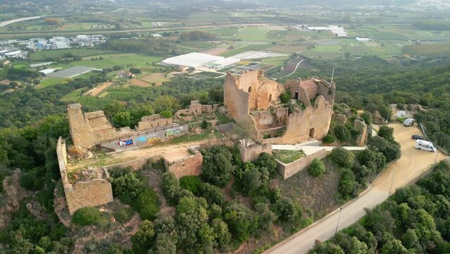 Ruined castle in Europe aerial footage cinematic medieval era Views from above Full castle background of cultivated fields Palafolls Barcelona