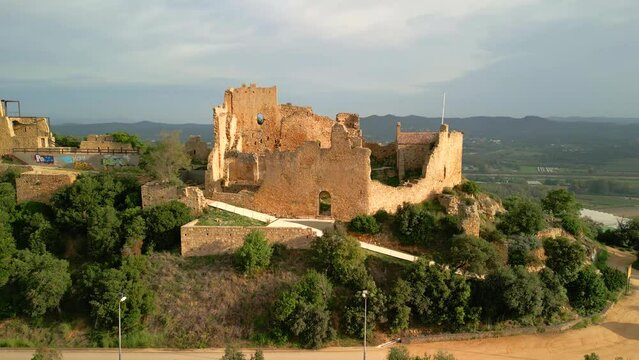 Ruined castle in Europe aerial footage cinematic medieval era Amazing views of Palafolls castle in Barcelona at sunset cloudy day