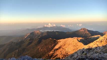 sunset over the mountains , above the clouds with sunny beams. Profitis ilias mountain in greece