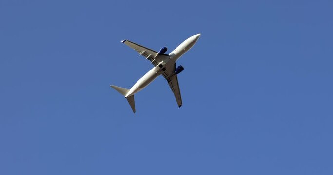 Small white plane flying over blue sky