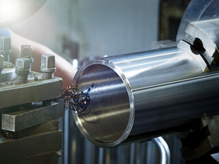 Closeup processing a metal pipe on a lathe.
