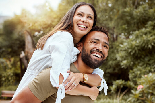 Love, happy and nature with couple and piggy back for spring, peace and relax in countryside park together. Smile, freedom and summer with man and woman hug for holiday, trees and grass field