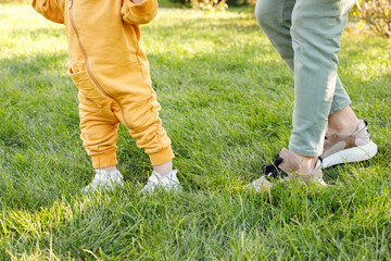 mom and baby first steps in the park for a walk