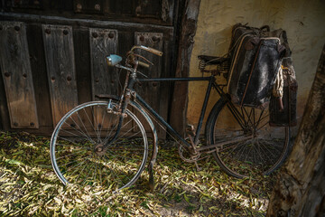 Old bicycle, in a rustic village in Spain, Vintage style, with old stone and wood background