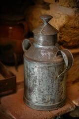 Old milk churn, tin bucket for milk, in a rustic town in Spain, Vintage style, with old stone and wood background