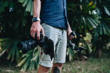 Man videographer is standing outdoors with his camera and gimbal