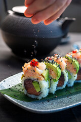   sushi on a plate sushimaster decorates sushi with sesame