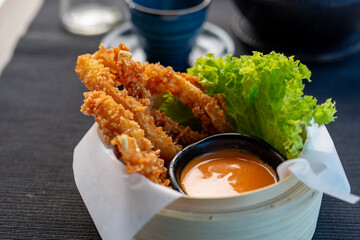 Shrimps fried in panko served with mango sauce. Bamboo basket with appetizers