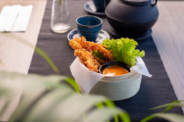Shrimps fried in panko served with mango sauce. Bamboo basket with appetizers