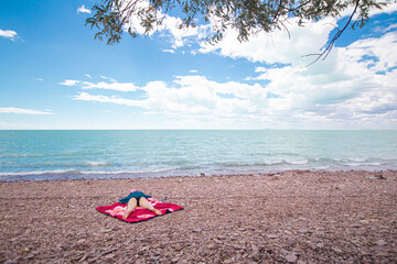 girl lying on the sandy shore of the ocean, resting from the bustle of the city