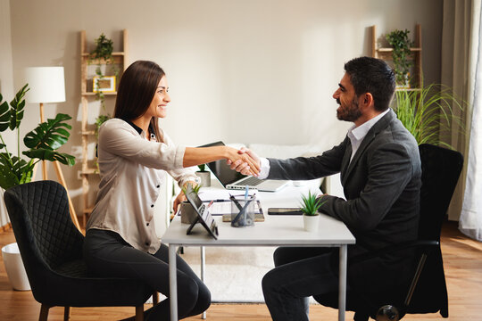 Young woman shakes hands with a business man at a business meeting