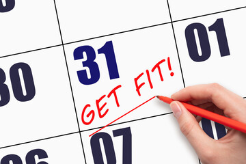 31st day of the month.  Hand writing text GET FIT and drawing a line on calendar date. Save the...