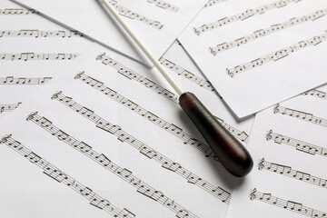 Conductor's baton on sheet music, closeup view