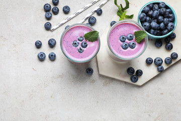 Freshly made blueberry smoothie on light grey table, flat lay. Space for text