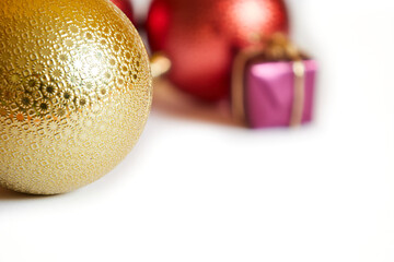 red and gold christmas balls with purple present box on white background isolated