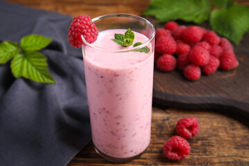 Glass of tasty fresh raspberry smoothie on wooden table