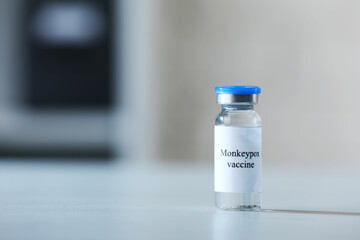 Monkeypox vaccine in vial on white table, space for text