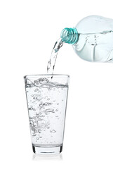 Pouring soda water from bottle into glass on white background