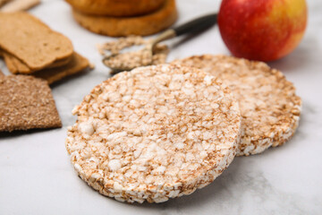 Rice cakes and rusks on white marble table, closeup