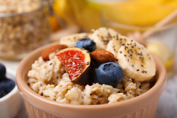 Bowl of oatmeal with blueberries, almonds, banana and fig pieces, closeup