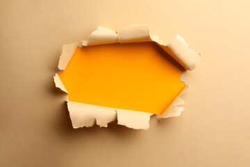 Hole in light beige paper on yellow background