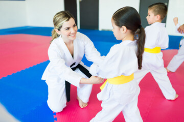 Martial arts coach teaching taekwondo to a toddler