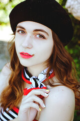 Fashion portrait of young, happy, elegant redhead curly woman, girl in hat and casual clothes. French style. Walking, relax in the city street. Sunny day.
