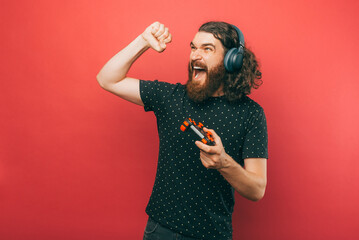 Excited young bearded hipster man gamer celebrating victory. © Vulp