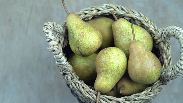 Pears in basket on a wooden background. Fruit harvest. Autumn still life. Pear variety Bera Conference. Vitamin food.