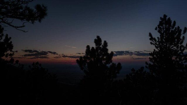 Time-lapse of a blazing red sunset behind trees on the high plains of central Wyoming.  Shot from near Casper WY, in 4K