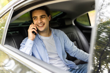 Young man in car on mobile phone. Filter vintage