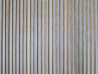 Vertical slatted wall with oak wood background.