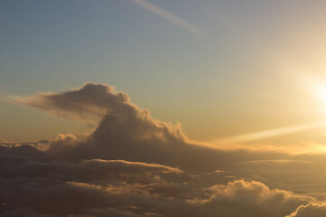 spectacular sunset seen from an airplane with clouds in the foreground and in the distance
