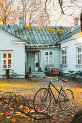 Helsinki, Finland - November 7, 2017: City bicycle parked in front of small house. Stone paved patio. Calm sunset scene at Suomenlinna. Selective focus.