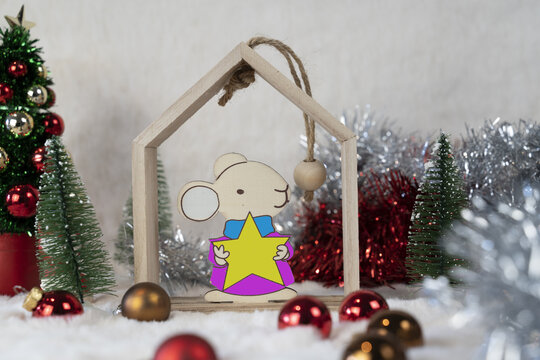 Petite souris en bois dans une maison et un décor de Noël