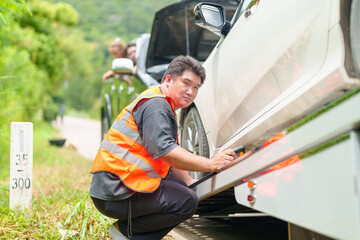 A tow truck with a broken car on a rural road