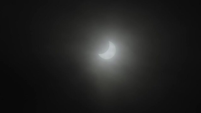 Handheld footage of a partial solar eclipse filmed in daytime.