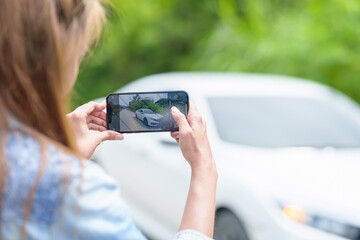 Car accident damaged by hand using smartphone to take pictures.