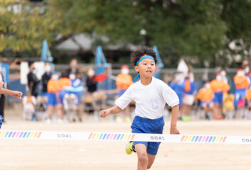 徒競走で一等賞になる小学生の男の子