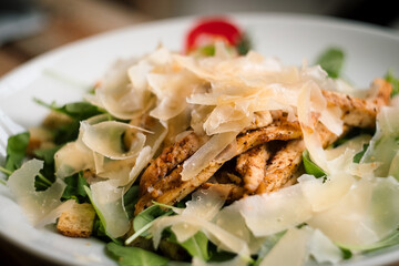 Caesar salad with roasted chicken breast, parmesan cheese, lettuce leaf, cherry tomatoes, corn and cheese dressing