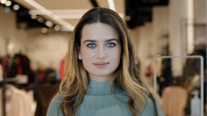 Young beautiful successful caucasian girl woman shopper consumer buyer standing in clothing store...