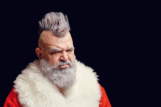 Evil aggressive gray-haired old man Santa in a bad mood. New Year and Christmas in the company of an unusual bad Santa. Severe dangerous Santa Claus with mohawk