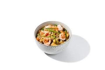 Fried rice with egg, shrimps and vegetables isolated on white background Traditional chinese food - fried rice with shrimps in ceramic bowl. Nasi goreng with fried rice, prawn and egg
