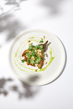 Baked Eggplant With Cheese On White Table With Harsh Shadows. Aesthetic Italian Food - Baked Aubergine On White Plate. Stuffed Eggplant In Minimal Style. Stuffed Aubergine In Vegan Menu.