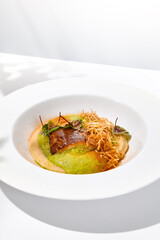 Roasted fish with crispy skin, celery cream and fresh herbs espuma. Fried halibut fillet on mashed celery and crunchy potatoes. Roasted fish fillet in elegant restaurant menu